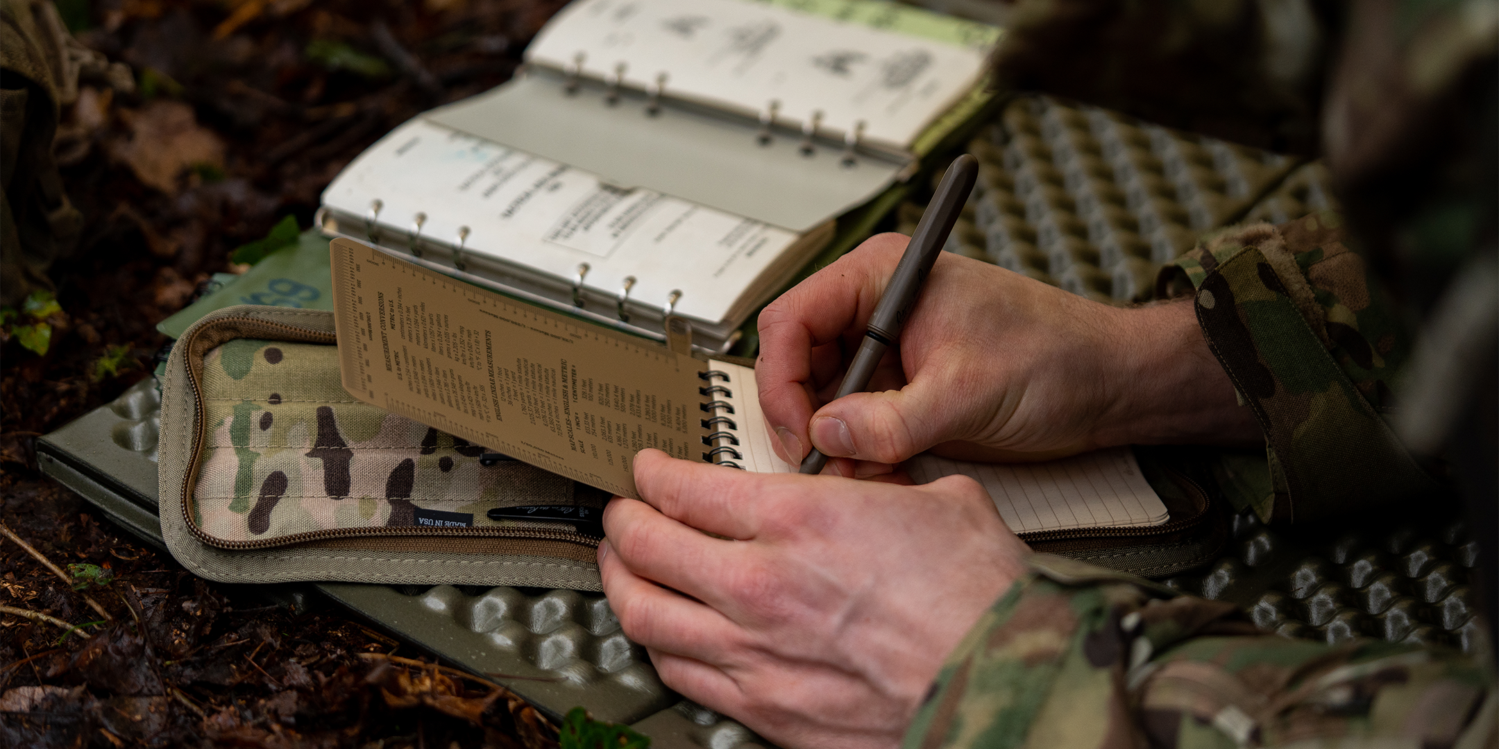 military personnel writing in notebook